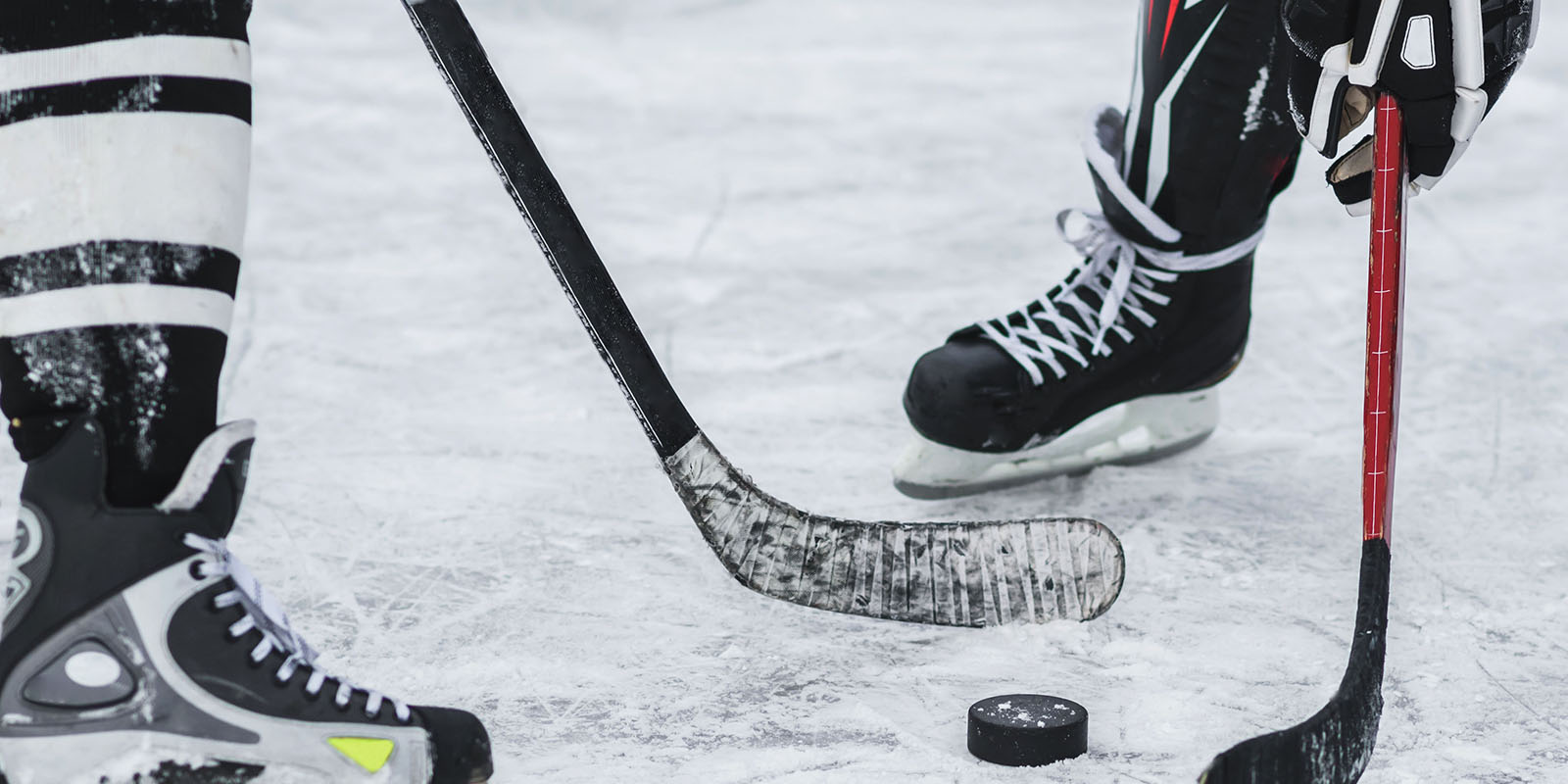 2 ice hockey players and a puck